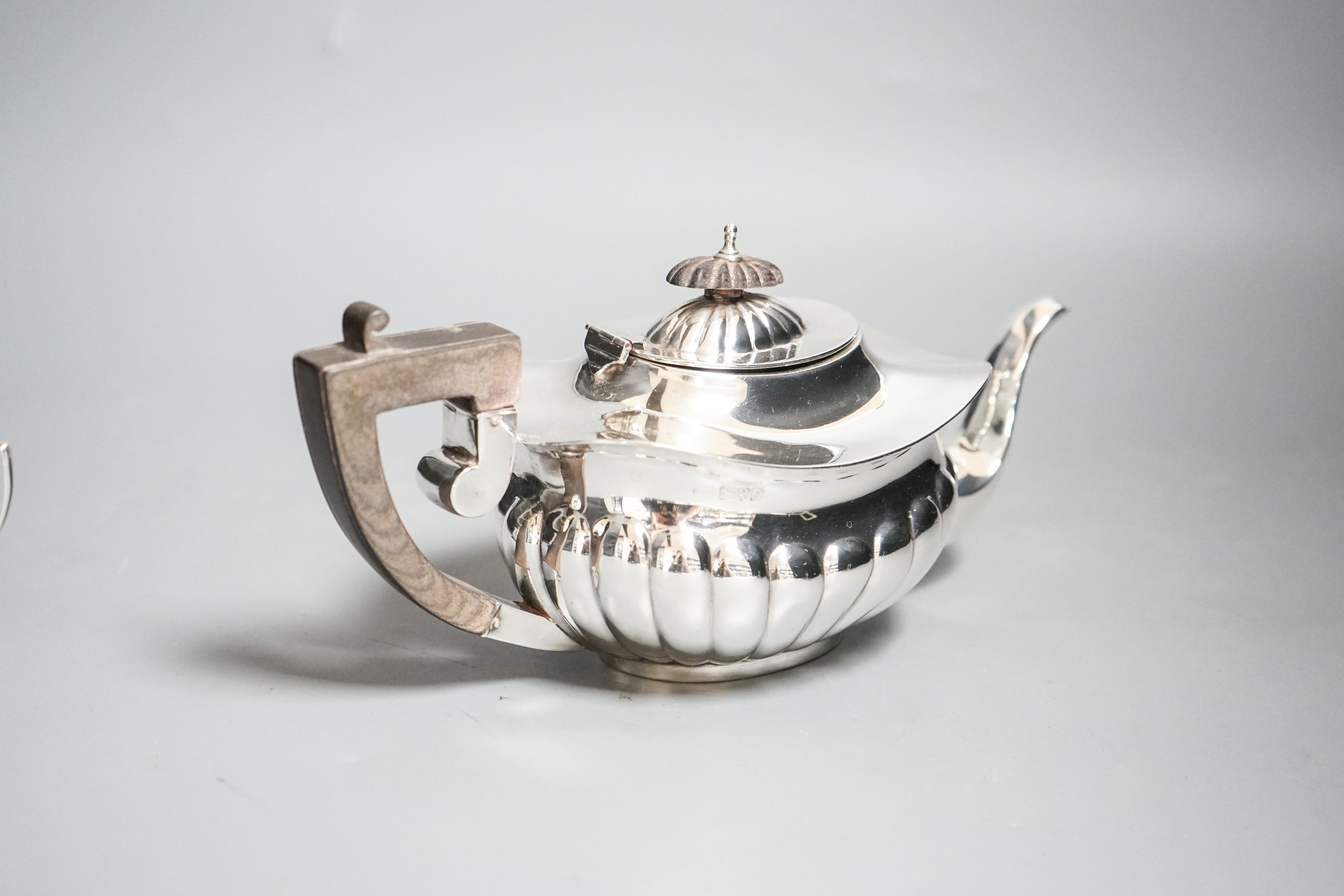 An Edwardian demi-fluted silver three piece bachelor's tea set, Chester, 1909, gross 15.5 oz.